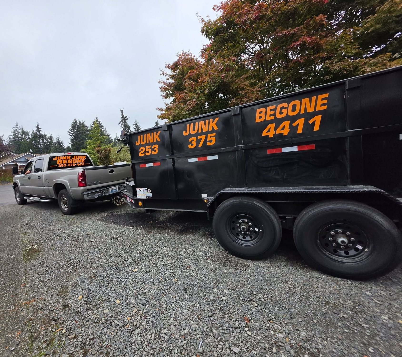 Junk Junk Begone branded black dump trailer and Silverado pickup